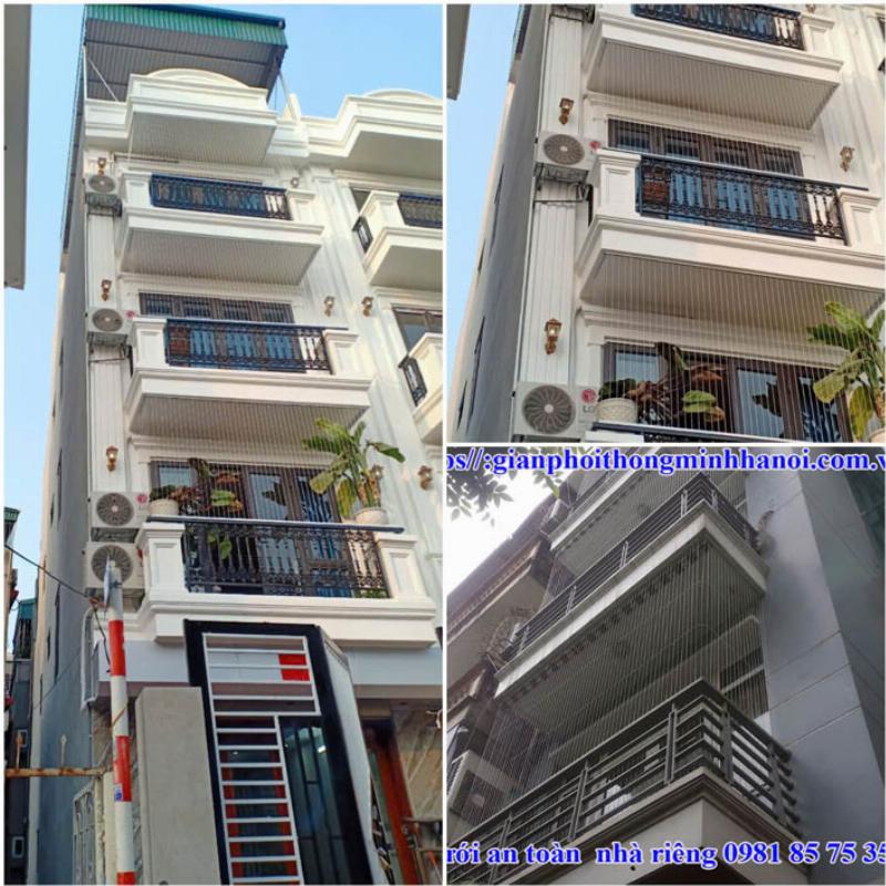 Hình ảnh một chiếc giá phơi quần áo inox dạng chữ H truyền thống đặt trên sân thượng, phơi nhiều quần áo người lớn và trẻ em dưới nắng